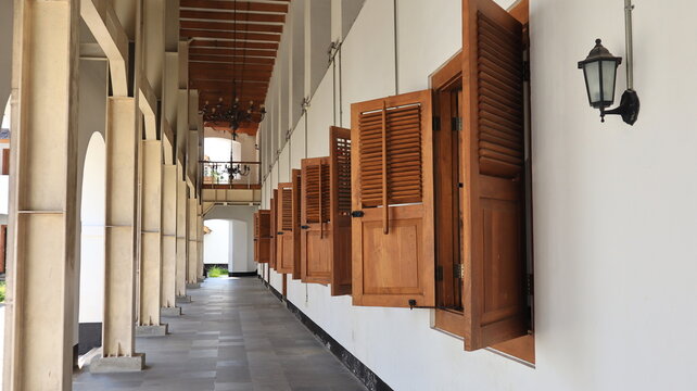 A row of brown wooden windows appears open on an old building.