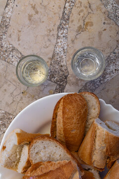 Fresh Sliced White Bread and Traditional Rakija Served Outdoors on Stone Garden Table