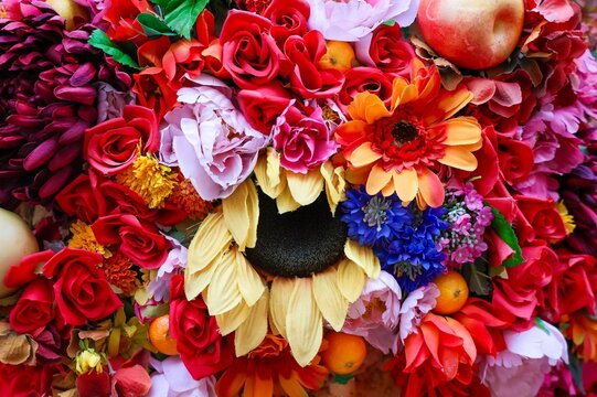 Colorful artificial fabric flowers and decorative fruits background