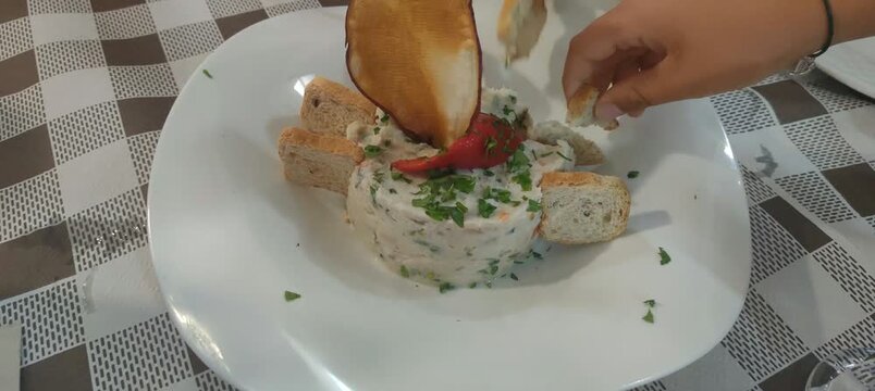 Woman eating russian salad with bread in a restaurant