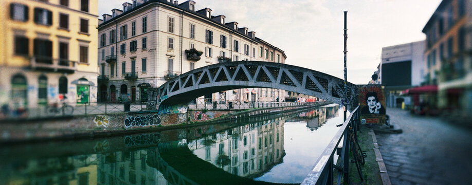 Panoramic view of the Naviglio Grande canal, featuring the iconic iron pedestrian bridge known locally as El pont de fer Milan, Italy, Europe