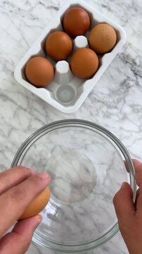 Breaking an egg is the process of fracturing an eggshell to extract the yolk and whites inside.