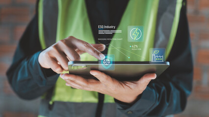 ESG industry eco technology concept sustainable manufacturing, environmental governance industrial worker using tablet with emissions reduction chart and green energy factory icons, Data, analysis © HappyEva