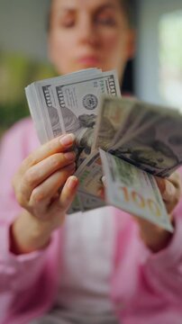 Woman counting US Dollar bills, close-up. Concept of investment and success