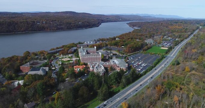 Aerial view of The Culinary Institute of America campus along the Hudson River with autumn foliage and a highway in Hyde Park, New York, United States.
