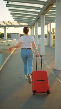 Caucasian woman pulling a suitcase and running, late for flight. 