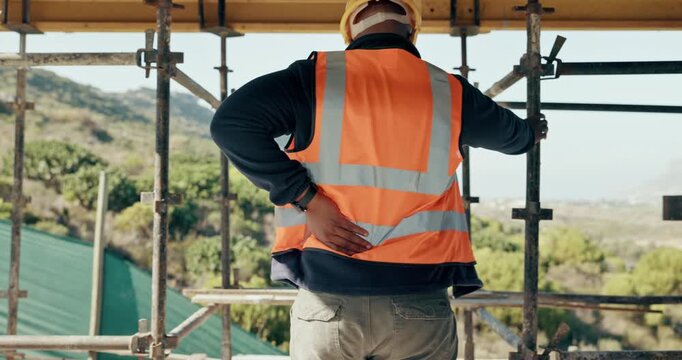 Construction site, man and back pain with ache for building, renovation and civil engineering mistake. Tired contractor, burnout and accident with industrial strain, architecture or maintenance