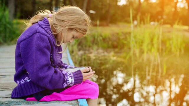Young beautiful girl reading e-book