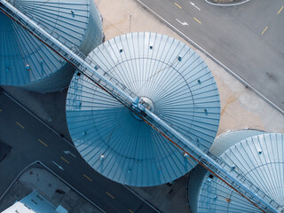 aerial view of blue industrial silo tops with metal structures and road © zhu difeng