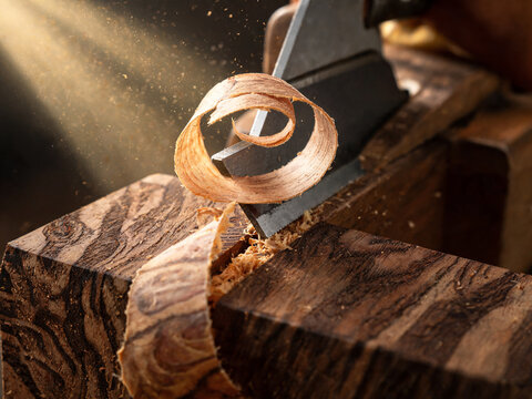 Wooden plane shaving raw walnut wood block