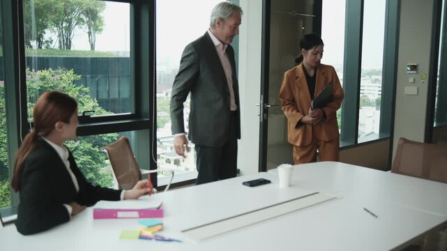 White senior male CEO boss interviews Asian female worker for company employment collaboration and job opportunity with career resume document in office meeting with human resources secretary woman.