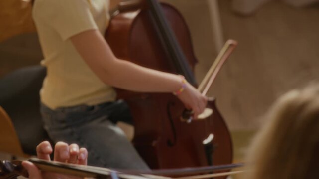 Cropped shot of Caucasian children practicing violin and cello during private music lesson at home. Footage is ideal for promoting music schools, youth arts programs, and private tutoring services