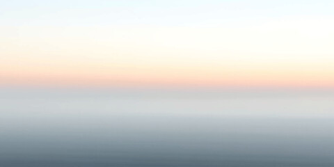 Fototapeta premium A tranquil seascape at dusk, where the sky fades from pale orange to soft pink, meeting the calm, muted blue of the water.
