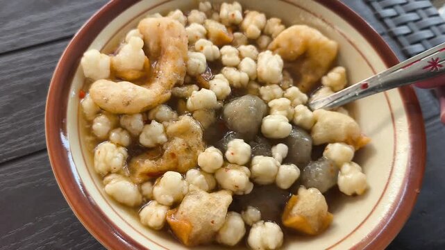 aci, appetizer, asian cuisine, bakso aci, batagor, bowl, broth, ceramic tableware, chili flakes, cilok, close-up shot, comfort food, culinary experience, dark background, dining, dinner, eating, food 