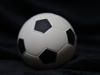Una toma de cerca de una pelota o balón de fútbol con luces en un fondo negro con algo de desenfoque  © Elika R