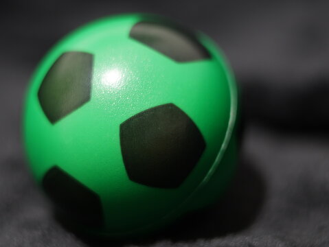 Una toma de cerca de una pelota o bal&oacute;n de f&uacute;tbol con luces en un fondo negro con algo de desenfoque 