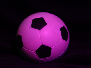 Una toma de cerca de una pelota o balón de fútbol con luces en un fondo negro con algo de desenfoque  © Elika R