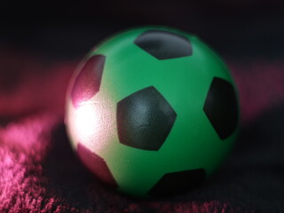 Una toma de cerca de una pelota o balón de fútbol con luces en un fondo negro con algo de desenfoque  © Elika R
