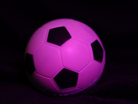Una toma de cerca de una pelota o bal&oacute;n de f&uacute;tbol con luces en un fondo negro con algo de desenfoque 