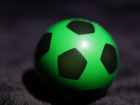 Una toma de cerca de una pelota o bal&oacute;n de f&uacute;tbol con luces en un fondo negro con algo de desenfoque 