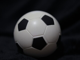 Una toma de cerca de una pelota o balón de fútbol con luces en un fondo negro con algo de desenfoque  © Elika R