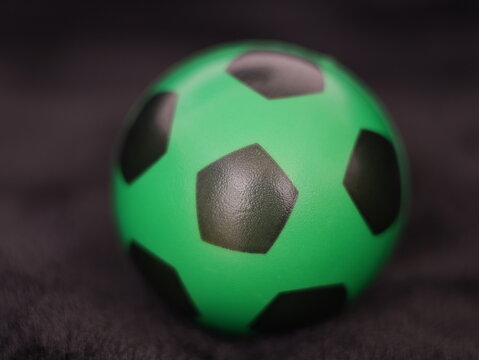 Una toma de cerca de una pelota o bal&oacute;n de f&uacute;tbol con luces en un fondo negro con algo de desenfoque 