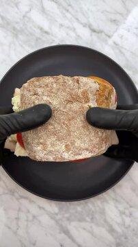 A delicious and aromatic Italian-inspired sandwich featuring basil pesto, whole wheat  bread, and fresh ingredients like mozzarella, tomatoes, and Turkey ham.