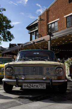Classic soviet vintage cars lada vaz 2101 on city street exhibition near cafe under blue sky
