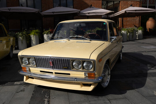 Classic soviet beige sedan car lada vaz 2103 with chrome grill at city street terrace exhibition under sunlight