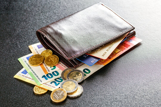 Various currencies in purse close-up.Open wallet with euro banknotes.British coins , pound sterling.Dollars cash and credit cards.Finance concept