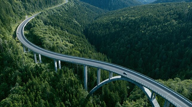 Pont autoroutier moderne serpentant &agrave; travers une vall&eacute;e bois&eacute;e