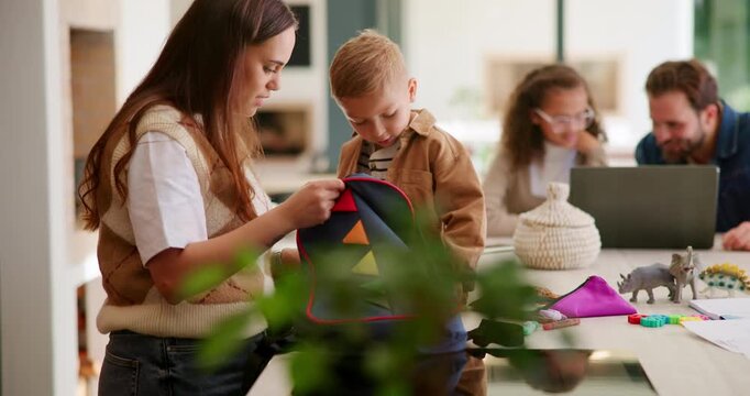 Backpack, help and mom with child in kitchen to prepare for school, morning routine and learning. Family, parents and mother with boy for packing bag for development, education and ready for academy
