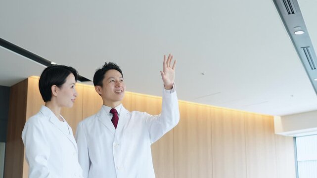 画面を見ながら会話する白衣の男女グループ