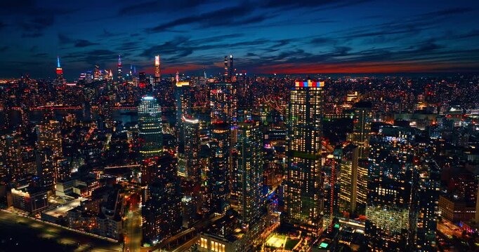 Dense urban landscape of modern American metropolis beautifully illuminated at night. Vibrant nightlife of New York City, USA. Drone footage.