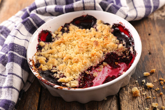 berry crumble in ramekin on wooden background