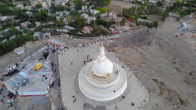 Cinematic pullback over Shanti Stupa revealing Leh valley and Himalayan Mountains