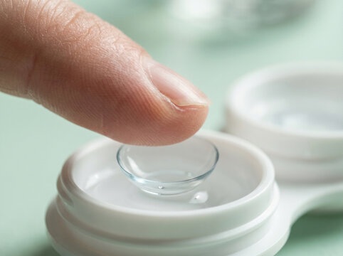 Finger touching contact lens in case medical-consultation