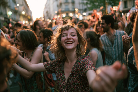 Happy young woman dancing in a crowded street during Fete de la Musique in France, illustrating live music, summer celebration, youth culture, and urban festival atmosphere