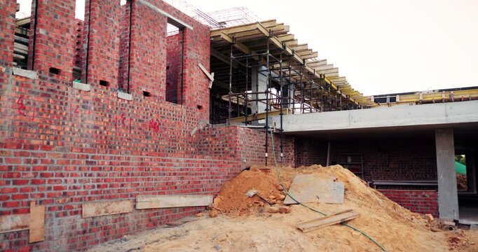 Construction, development and empty building outdoor, brick wall and concrete for engineering. Architecture, scaffolding and exterior with incomplete infrastructure, dirt and framework design at site