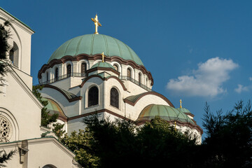 Green domes and golden crosses of Saint Sava Temple against blue sky in Belgrade, Serbia. Orthodox cathedral architecture. © jirka