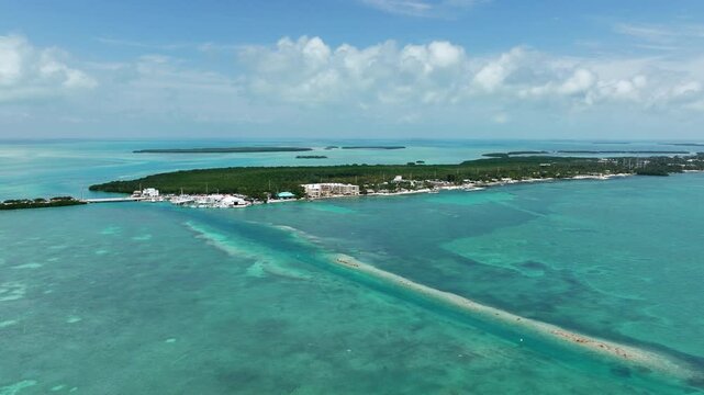 Cinematic aerial drone footage of turquoise shallow water, reef textures, mangrove islands, and marina coastline in the Florida Keys near Islamorada, Florida.