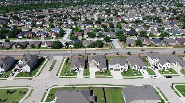 Main road corridor through Arlington, TX frames rows of homes, parked cars neatly kept lawns extending across dense suburban grid. Long sightlines along central roadway highlight traffic flow