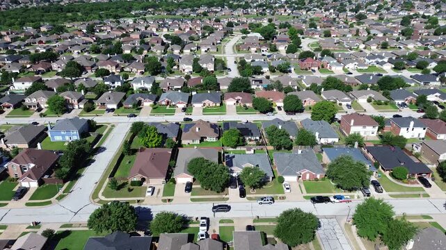 Intersecting street grid in Arlington, TX shows rows of homes with mixed roof colors, solar panels parked cars shaping residential pattern. Long parallel blocks tree spacing reveals upscale area