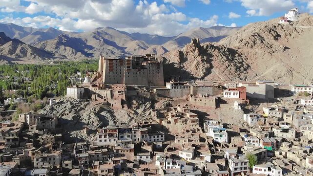 Aerial drone orbit of historic Leh Palace and Himalayan mountains.