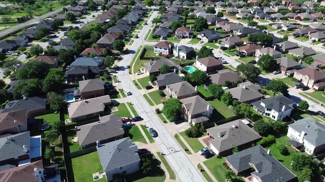Curved street alignment in Arlington, TX shows rows of homes with mixed roof colors, backyard pools scattered trees shaping residential pattern. Subtle elevation changes, master planned community