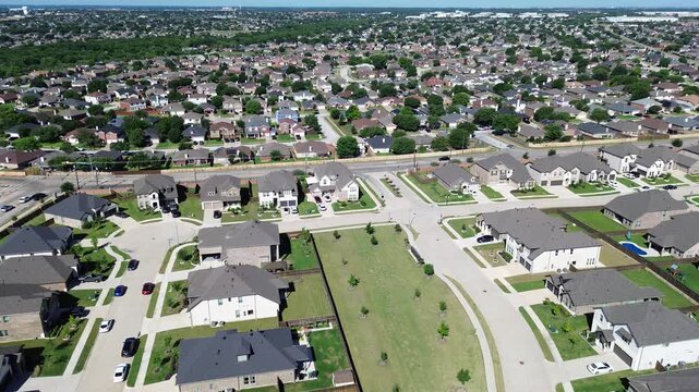 Dense residential blocks in Arlington, Texas extend across wide suburban area, intersecting streets cul-de-sac forming neighborhood pattern. Uniform shingles, parked cars, master planned community