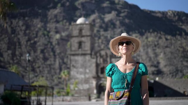 Senior woman enjoys her time at San Javier Mission in Baja California Sur, Mexico, smiling during an early morning adventure