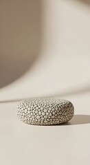 Fototapeta premium Minimalist Pebble Stone Podium for Product Display on Neutral Background