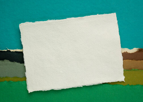 small blank sheet of watercolor paper against abstract art paper landscape