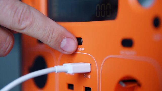 Person plugging USB cable into portable power station. Charging electronic device using battery pack. Sustainable energy and mobile power supply concept. Slow Motion Effect.